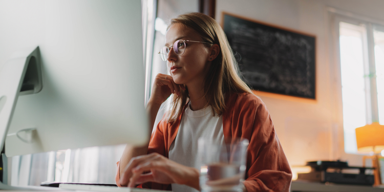 Woman in glasses looking at a computer screen