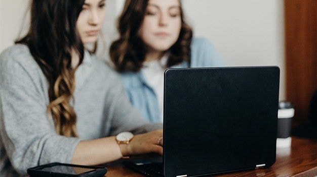 Project managers taking in an ad-hoc project request at a desk with a laptop