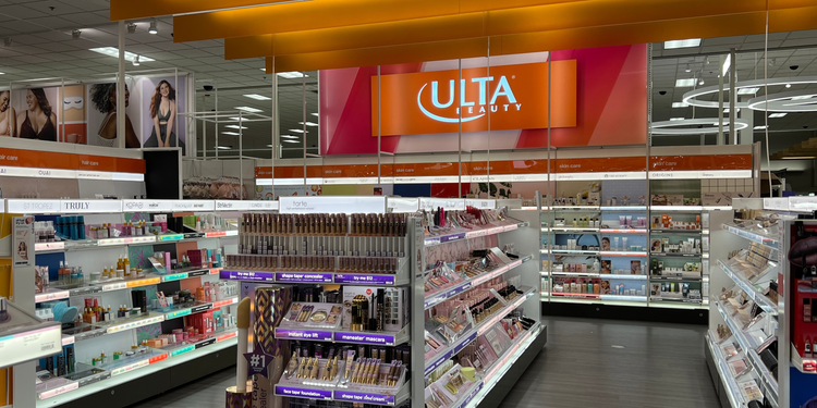 Interior of an Ulta Beauty store showing neatly arranged shelves of cosmetics and skincare products. The shelves display various brands, with categories labelled for hair care, skin care and makeup.