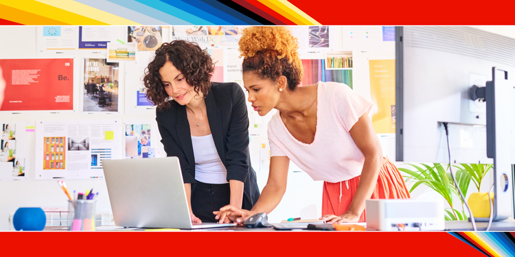 Two marketers looking at a laptop in an office.