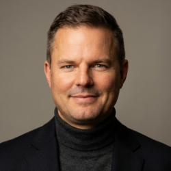 A person in a black suit AI-generated content may be incorrect.