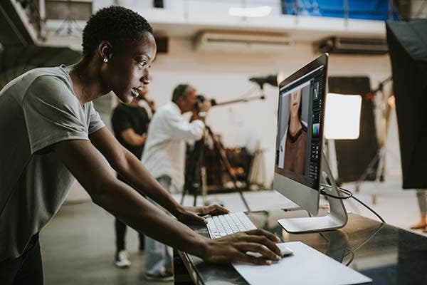 photographer editing a photo on a monitor in a large studio