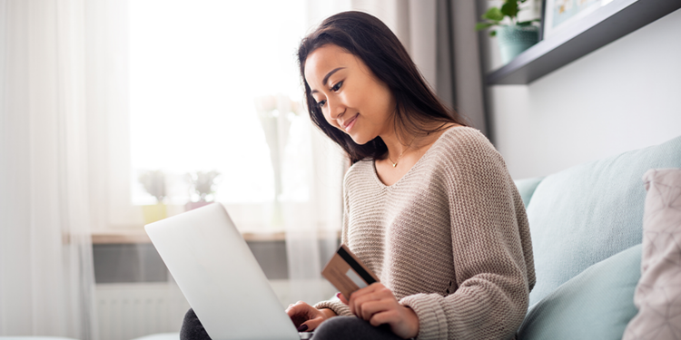 An ecommerce shopper preparing to complete a personalized purchase with credit card in hand.