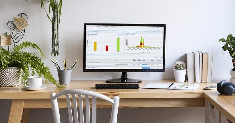 A home office set up with a laptop open to work management platform