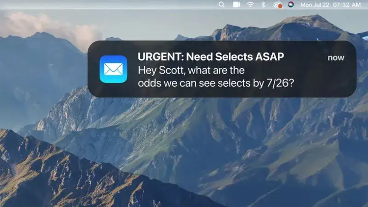 An urgent email notification appears over a computer screen’s background image of mountains.