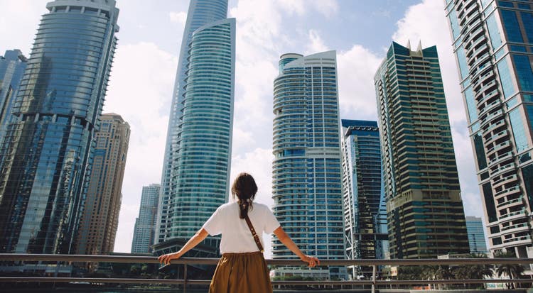 A woman looks out at a big city skyline