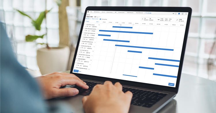 A person sits at their desk on a laptop, using Workfront's Scenario Planner application