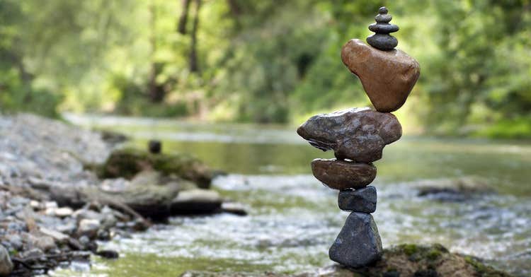 A cairn of rocks sits in the middle of a stream