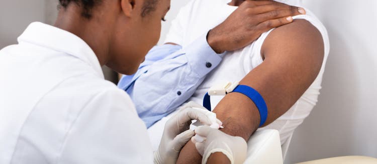 Doctor Injecting Patient With Syringe To Collect Blood