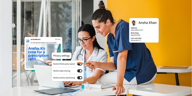 Two healthcare workers collaborating on a laptop.