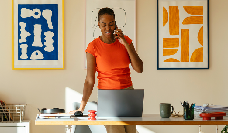Marketer working on a laptop while talking on the phone