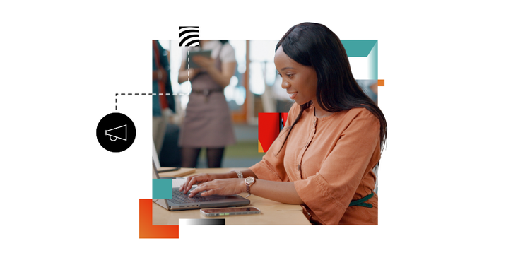 An African-American woman wearing a peach-colored blouse sits at a desk and types on a laptop keyboard while working on an agile marketing strategy project.