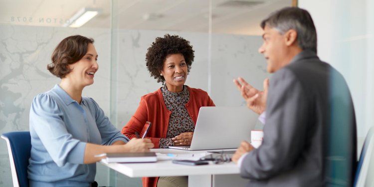 Groupe de trois personnes discutant dans un bureau
