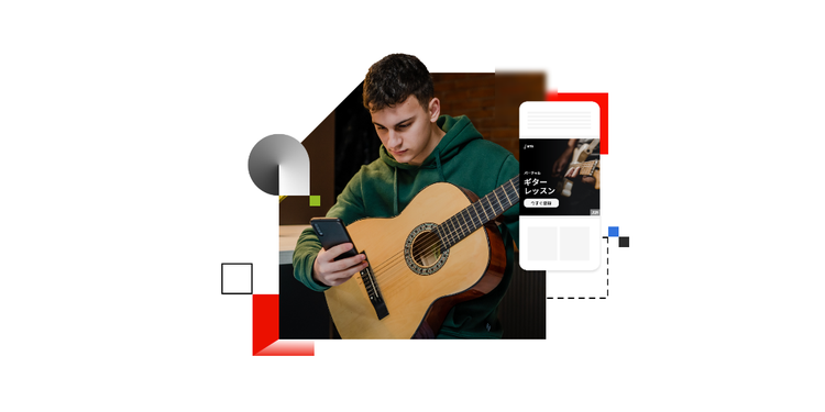 A young man looks at an advertisement for guitar lessons while holding his guitar to show an example of targeted marketing.