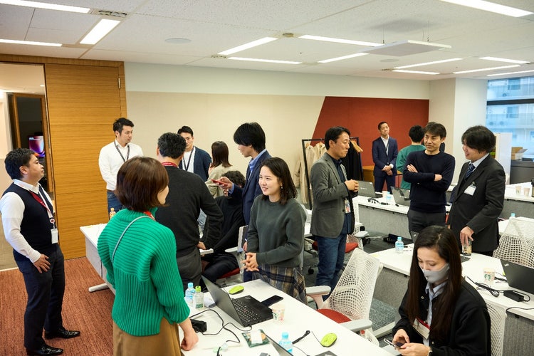 空港のターンテーブルの周りに集まっている人達 低い精度で自動的に生成された説明