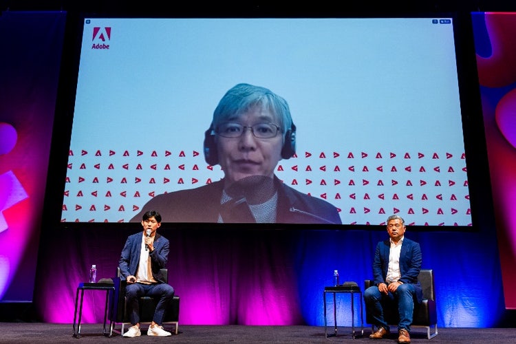ステージで演奏しているバンドと前にいる女性 中程度の精度で自動的に生成された説明