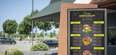 Digital menu board in front of building.