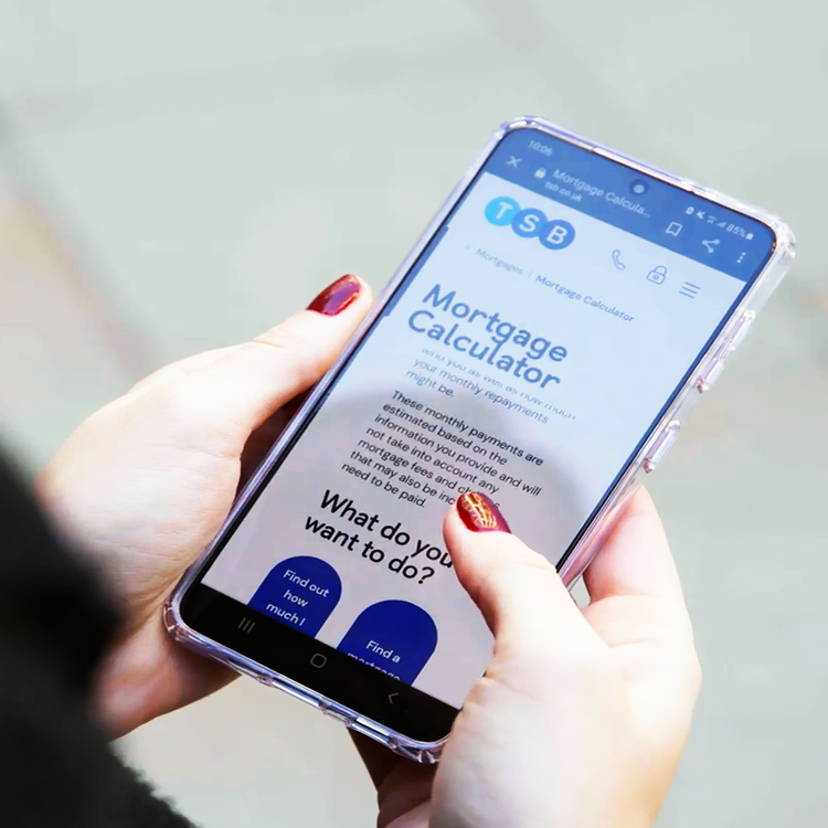 Woman using the TSB Mortgage Calculator on her cell phone