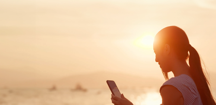 background image of silhouette of woman looking at mobile phone