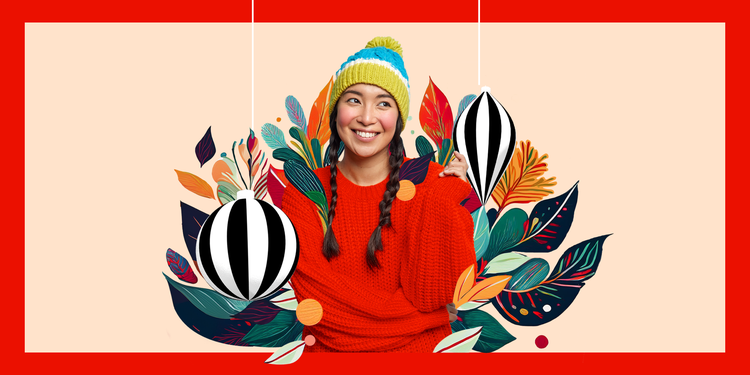 Smiling woman in a colourful winter hat and red pullover surrounded by festive foliage and hanging ornaments on a bright, decorative background.
